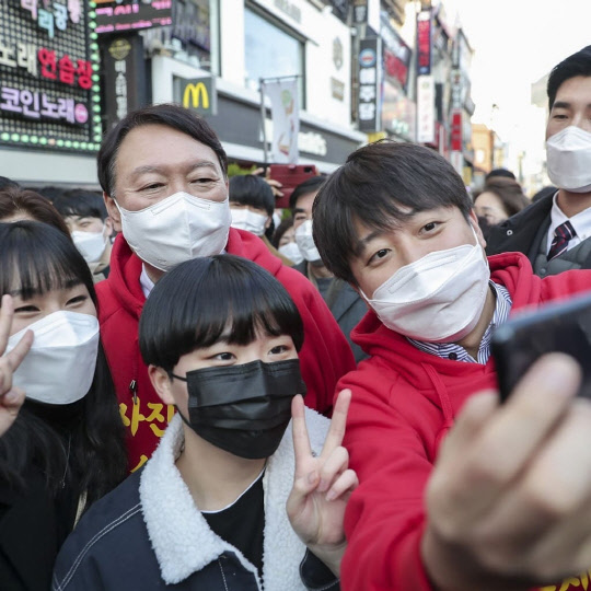 지난 2021년 이준석(오른쪽) 국민의힘 당시 당대표가 대통령선거 선거대책위원회를 이탈했다가 윤석열 당시 대통령후보(왼쪽·현 대통령)와 '울산 담판'으로 복귀를 결정한 이튿날(12월4일), 부산에서 '사진 찍고 싶으면 말씀주세요' 문구가 적힌 빨간색 후드티를 입은 채 거리 공동유세를 하고 있다.<이준석 국민의힘 전 당대표 페이스북>